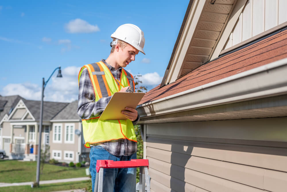 Contractor measuring roof edge | preparing for new eavestrough installation